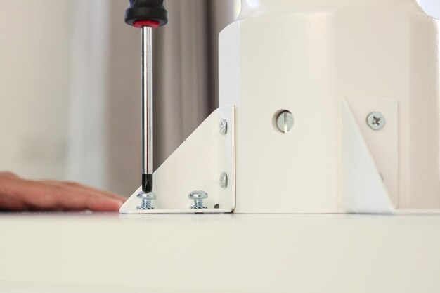 Photo asian man assembling white table furniture at home