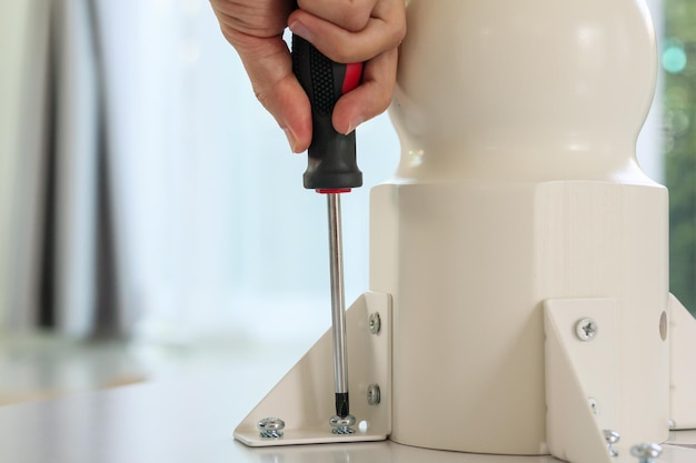 Asian man assembling white table furniture at home