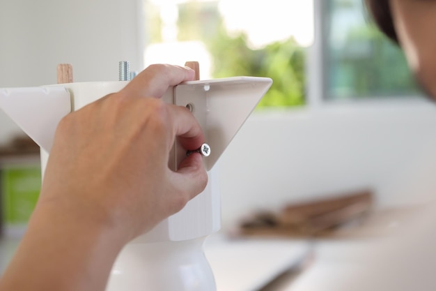 Asian man assembling white table furniture at home