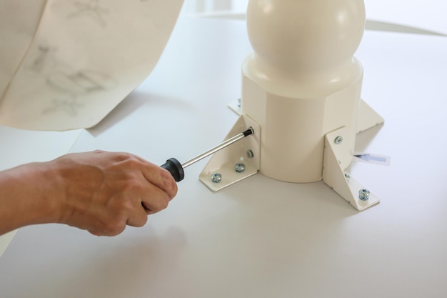 Asian man assembling white table furniture at home