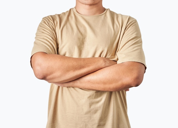 Asian man athlete, bodybuilder in brown earth tone t-shirt with arms crossed on the body isolated