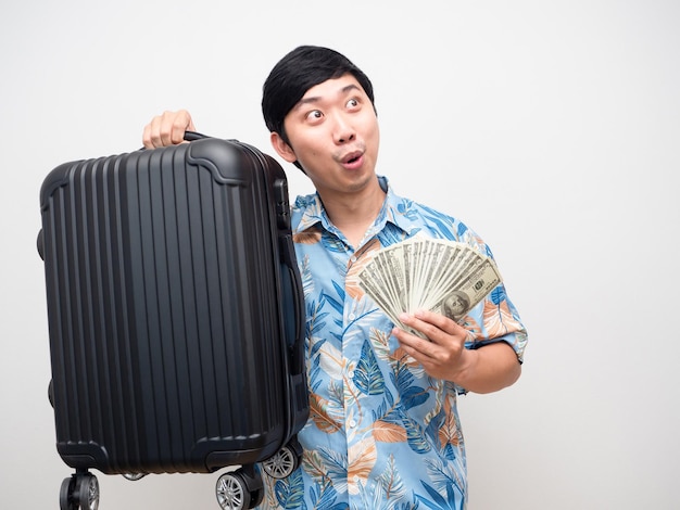 Asian man beach shirt holding luggage with money feels excited looking at copy space