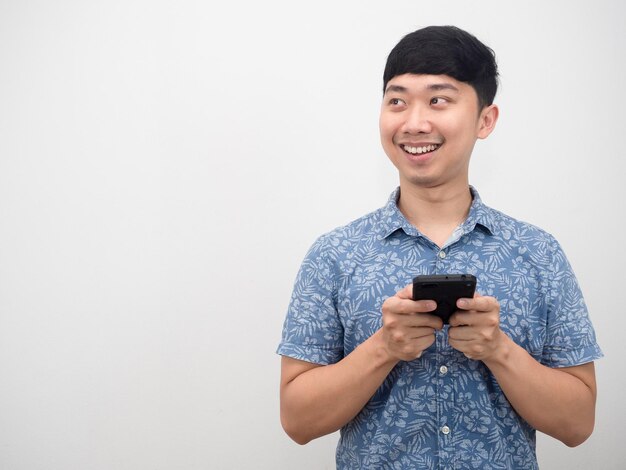 Asian man blue shirt holding smart phone happy smile and looking at copy space