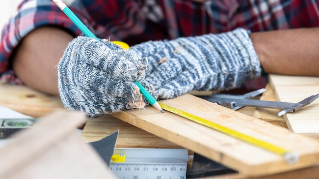 Asian man carpenter working on woodworking in carpentry shop Carpenter working on wood craft at workshop construction material wooden furniture Asian man works in a carpentry shop