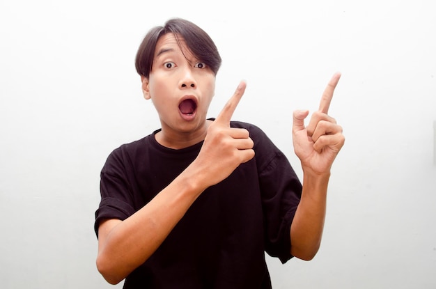 Asian man in casual shirt pointing hand on empty space. proud\
asian man with smile offers something