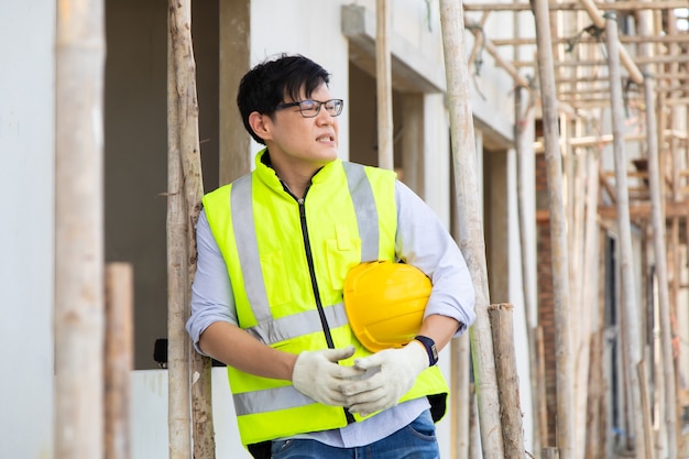 Asian man construction worker looking stressed on construction site.