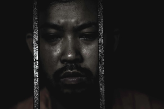 写真 鉄の囚人の概念に必死のアジア人タイの人々自由になることを望んでいる刑務所に投獄されている深刻な囚人