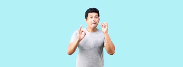 Asian man does a self test for Covid 19 on blue background