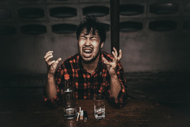 Asian man drink vodka alone at home on night timeThailand peopleStress man drunk concept