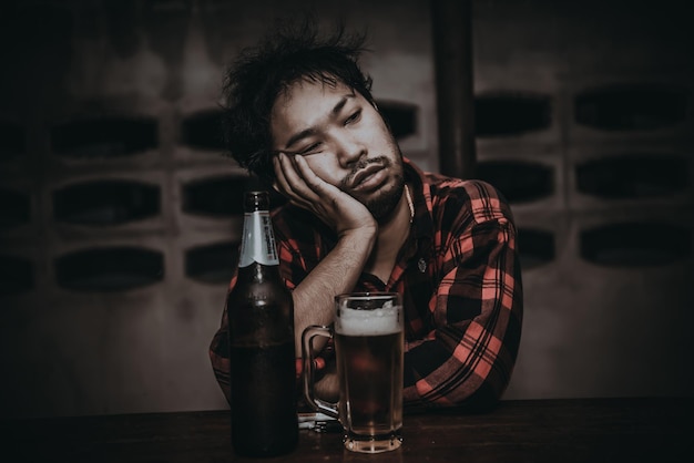 Asian man drink vodka alone at home on night timeThailand peopleStress man drunk concept