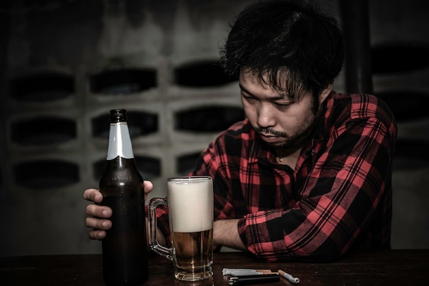 アジア人男性は夜に家で一人でウォッカを飲むタイ人ストレス男性酔ってコンセプト