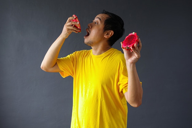 Азиатский мужчина ест свежие фрукты дракона