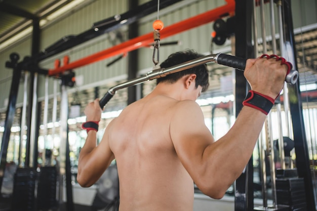 Foto uomo asiatico che si esercita con un barbell in palestra