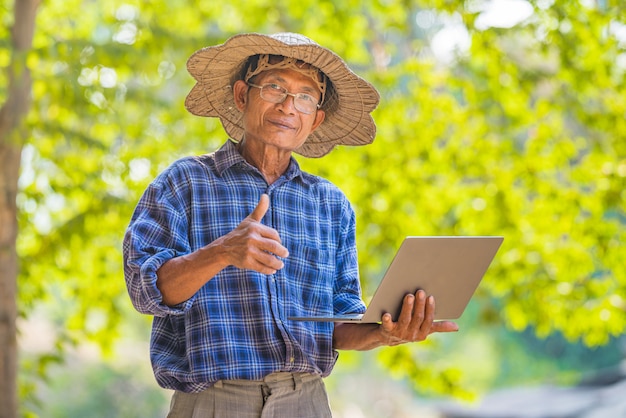 Азиатский фермер человек с смарт-телефон и ноутбук бизнес и концепция технологии, азиатский мужчина фермер на пустой копией пространства