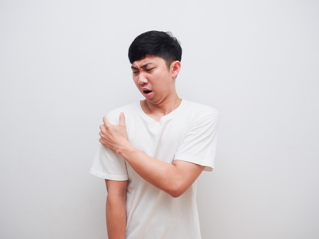 Asian man feel pain at his shoulder and touch his shoulder by left hand on white background