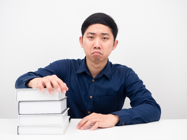 Asian man feeling bored about reading books on the table white background