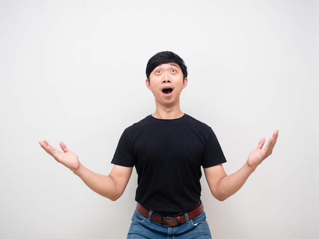asian man feels amazed looking above isolated