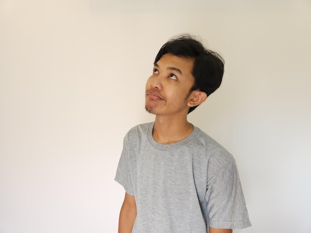 Asian man feels bored and facing up with isolated background