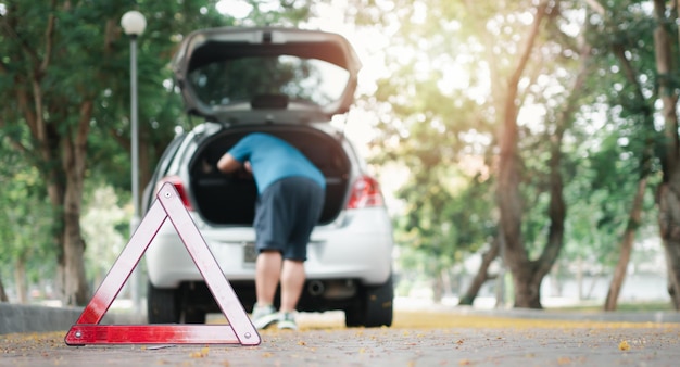 Asian man find tools in the car for car repair after a car breakdown on street