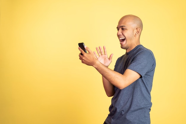 Asian man greeting while making a phone video call using his
smartphone