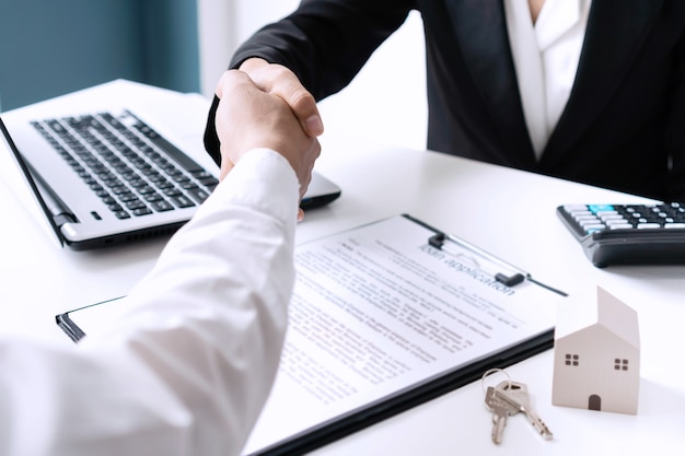 Handshaking dell'uomo asiatico con un agente immobiliare femminile