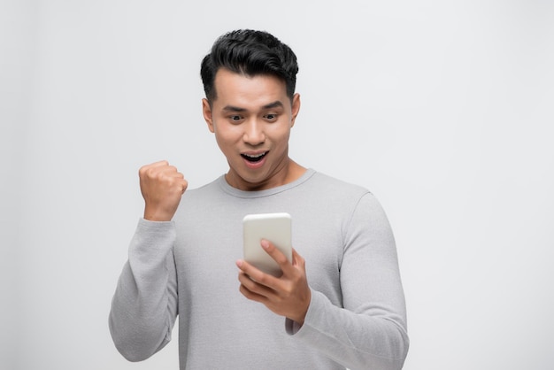 分離されたスマートフォンで何を見て幸せなアジア人男性