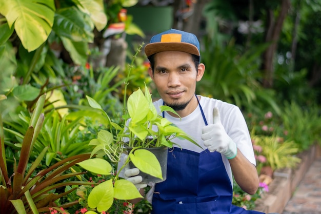 Азиатский мужчина счастлив продать сад растений в магазине