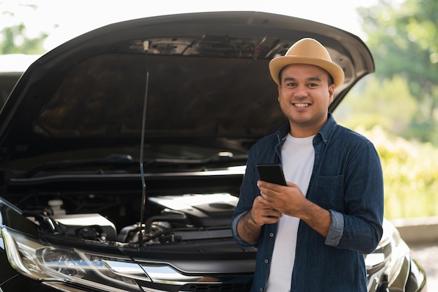 Asian man has  broken down car on the road he talking on phone to call someone to help or mechanics car service. Emergency assistance service