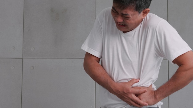 Photo asian man has severe stomach pains caused by appendicitis