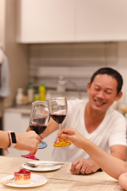 写真 ディナー パーティーで赤のグラスを乾杯友人とお祝いを持つアジア人男性