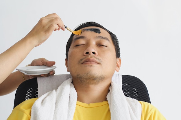 Asian Man having cosmetic mask in spa salon