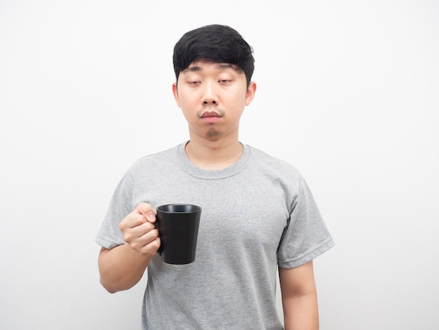 Asian man holding coffee cup sleepy emotion portrait