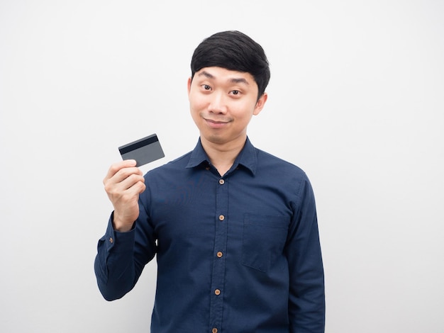 Азиатский мужчина держит кредитную карту счастливые эмоции