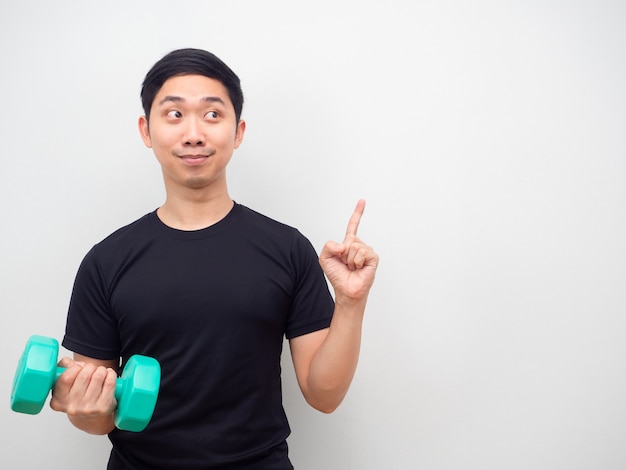 Asian man holding drumbbell happy face point finger at copy space motivation for workout concept