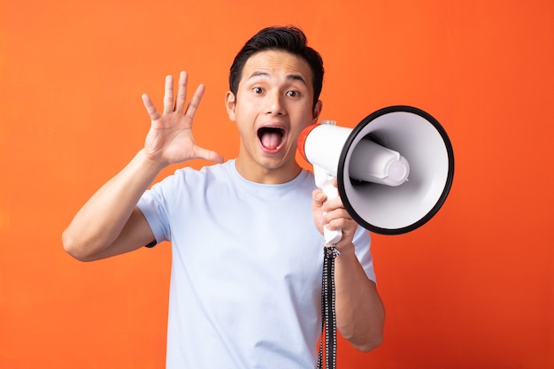 Asian man holding megaphone and shouting