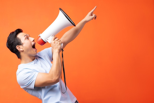 Asian man holding megaphone and shouting