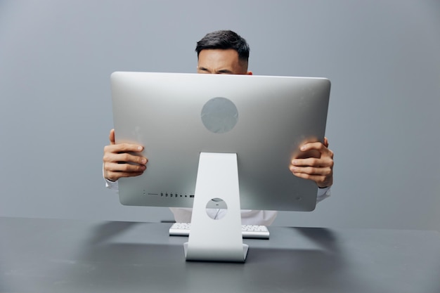 Asian man holding on to the monitor emotions office
technologies