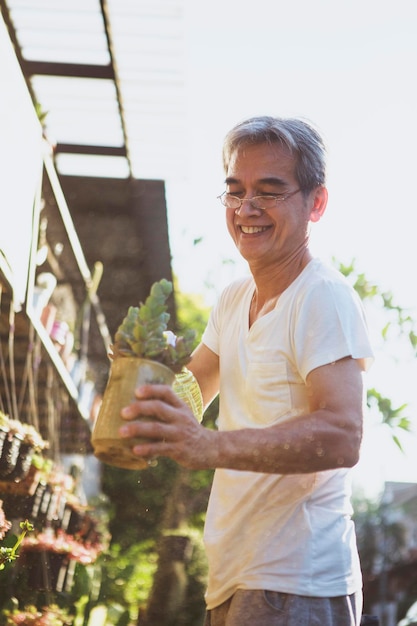 植木鉢と幸せそうな顔でこぼれるような笑顔を持っているアジア人男性