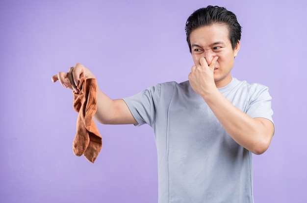 Asian man holding socks on purple