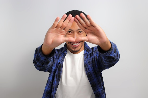 Foto un uomo asiatico sta creando una forma triangolare con le mani che simboleggia la protezione dell'ambiente