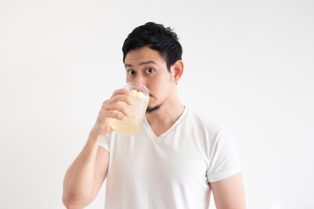 Asian man is drinking iced lemon soda on isolate white wall.