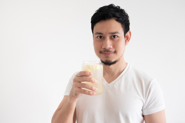 L'uomo asiatico sta bevendo la soda ghiacciata del limone sul bianco dell'isolato.