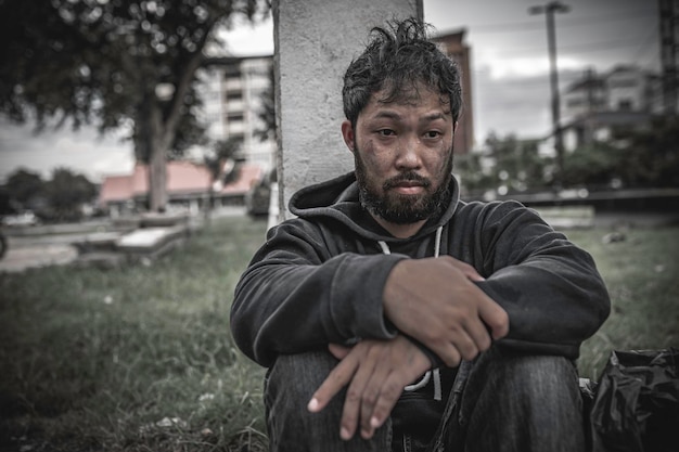 Foto l'uomo asiatico è senzatetto sulla strada lateraleuno sconosciuto deve vivere per strada da solo perché non ha famiglia