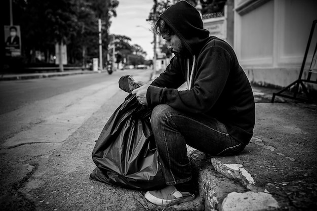 Foto l'uomo asiatico è senzatetto sulla strada lateraleuno sconosciuto deve vivere per strada da solo perché non ha famiglia