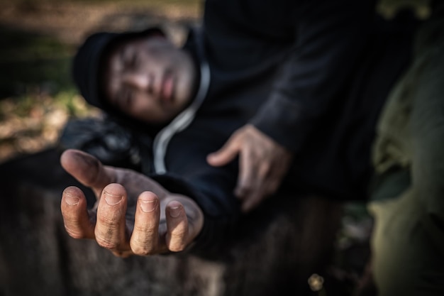 アジア人男性は脇道でホームレスです見知らぬ人は家族がいないので一人で道路に住まなければなりません