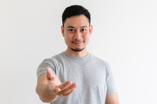 Asian man is making a hand gesture of invitation or offers help.