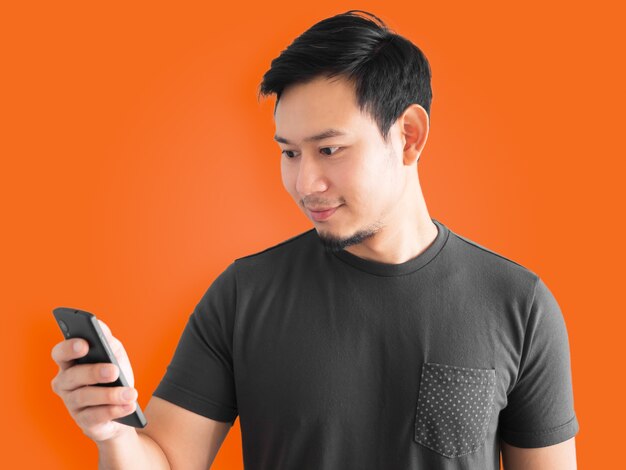 Photo asian man is using smartphone. black t-shirt mourn for thai king.