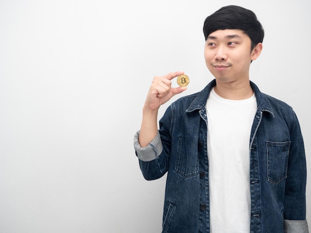 Asian man jeans shirt holding bitcoin looking at copy space