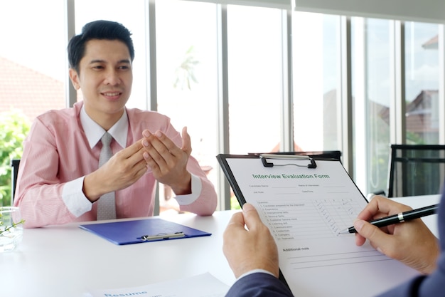 Uomo asiatico nell'intervista di lavoro al fondo dell'ufficio, ricerca di lavoro, concetto di affari