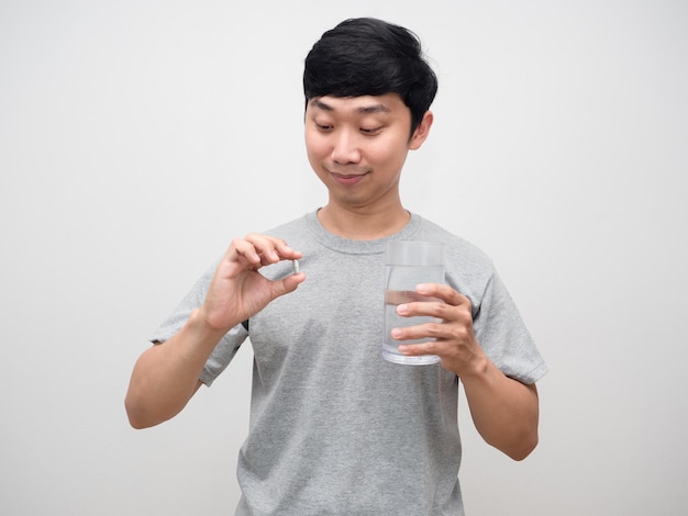 Asian man looking medicine with glass water in handGood healthy man